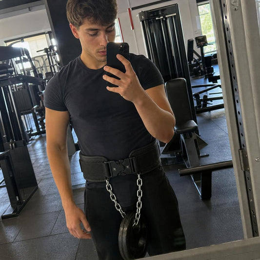 Persona usando el cinturón lastrado frente al espejo del gimnasio